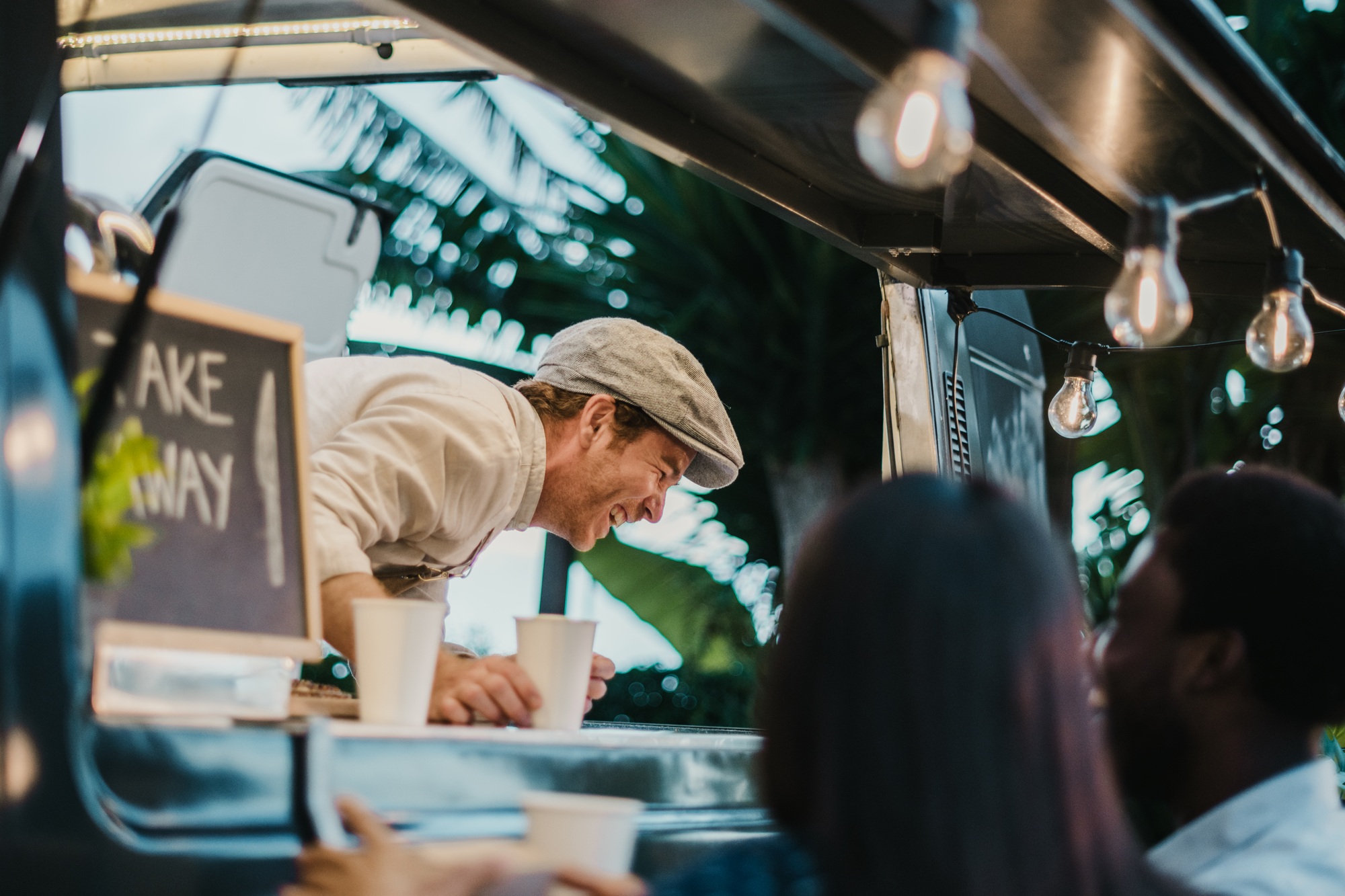 Food truck seller laughing at joke of customers